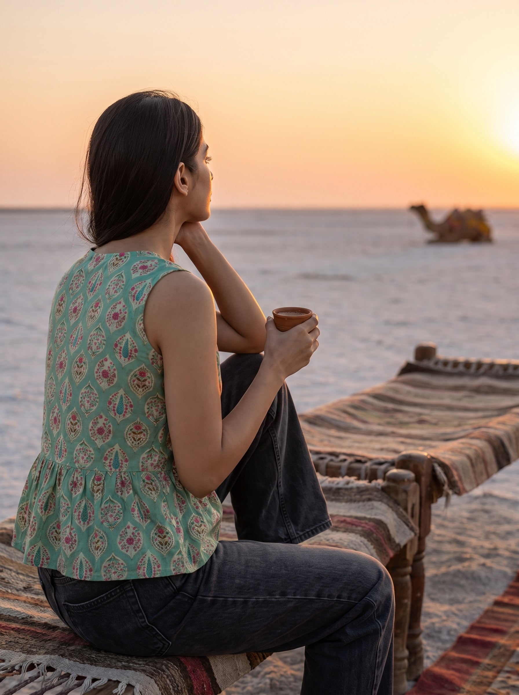 A stylish mint green sleeveless top featuring an elegant ethnic-inspired teardrop motif print all over. 
