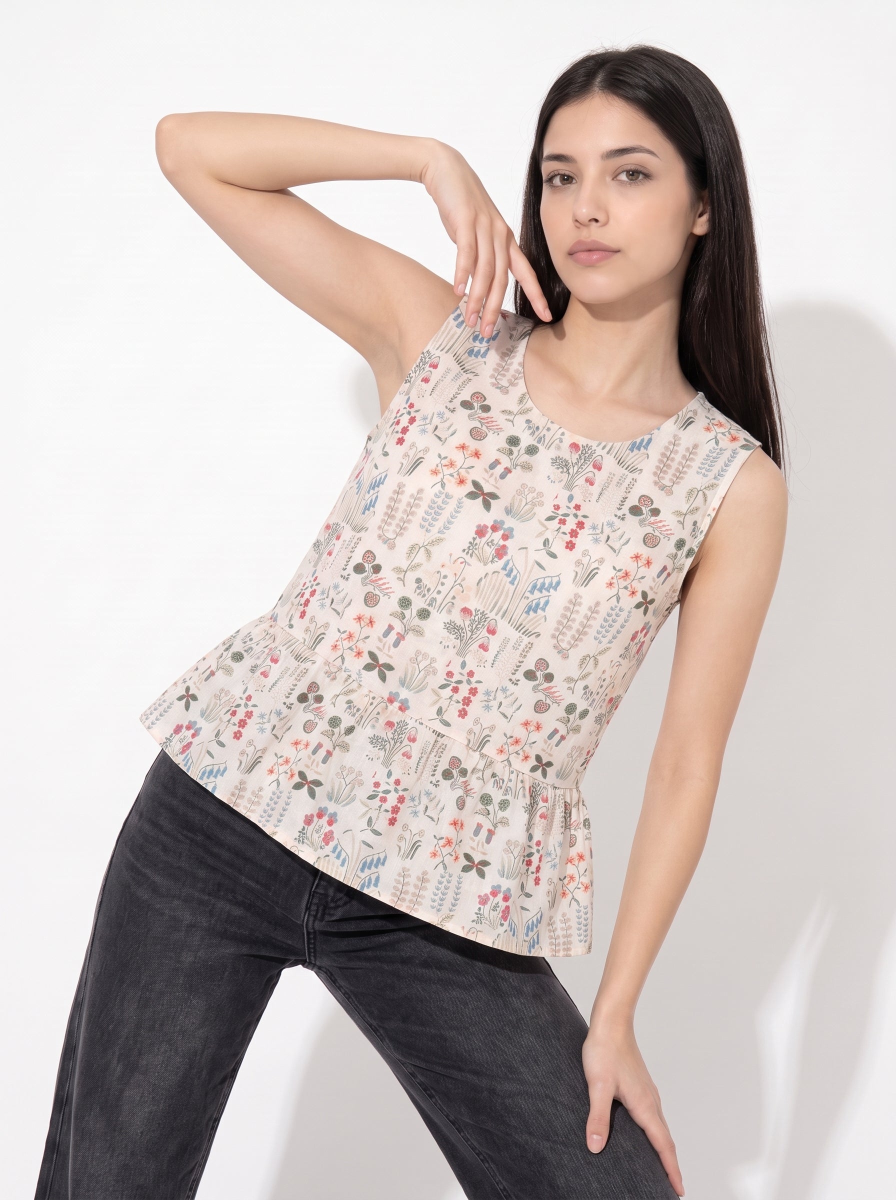 A graceful beige sleeveless top featuring delicate multicolor botanical motifs in soft red, blue, green, and earthy tones