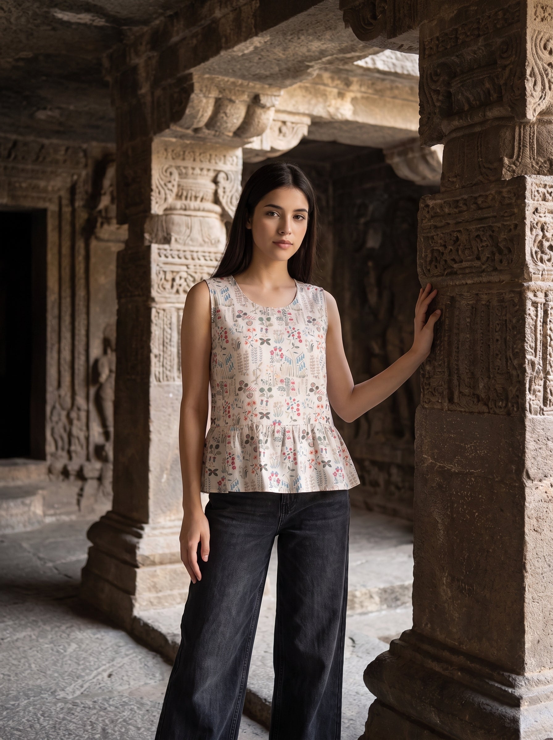 A graceful beige sleeveless top featuring delicate multicolor botanical motifs in soft red, blue, green, and earthy tones