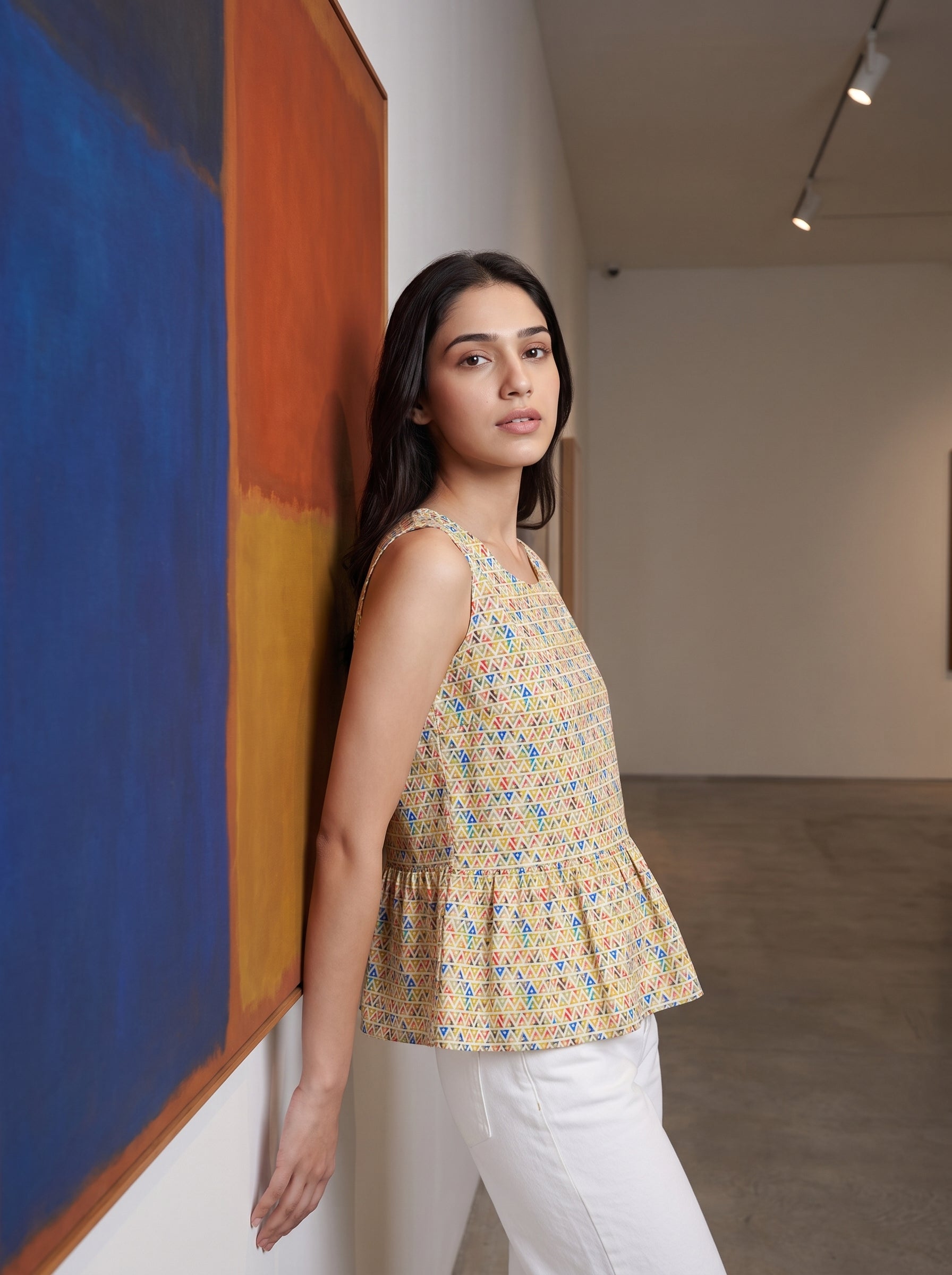 A fresh Multicolor sleeveless top featuring colorful geometric triangle motifs in blue, red, green, and orange tones. 