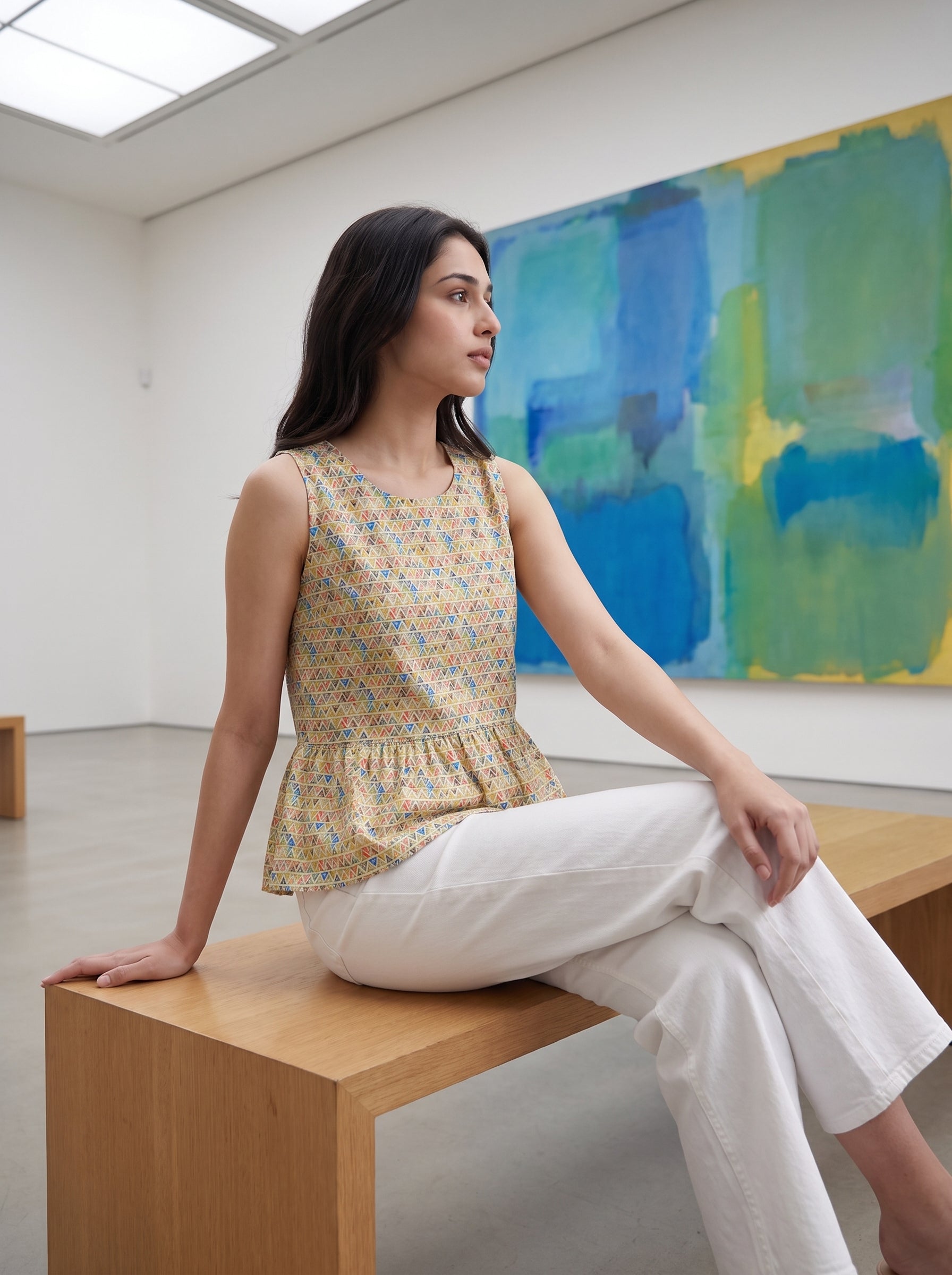 A fresh Multicolor sleeveless top featuring colorful geometric triangle motifs in blue, red, green, and orange tones. 