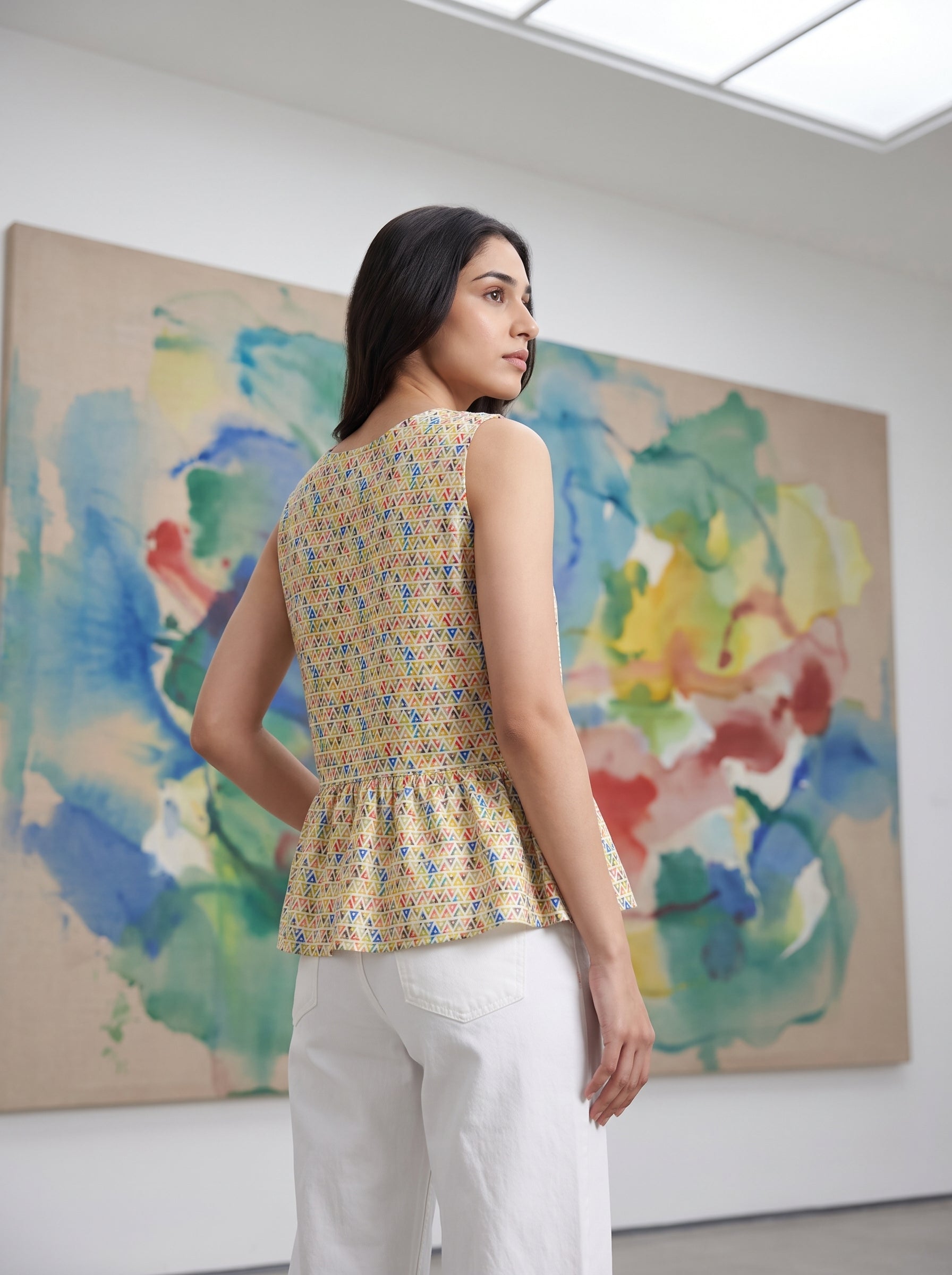 A fresh Multicolor sleeveless top featuring colorful geometric triangle motifs in blue, red, green, and orange tones. 