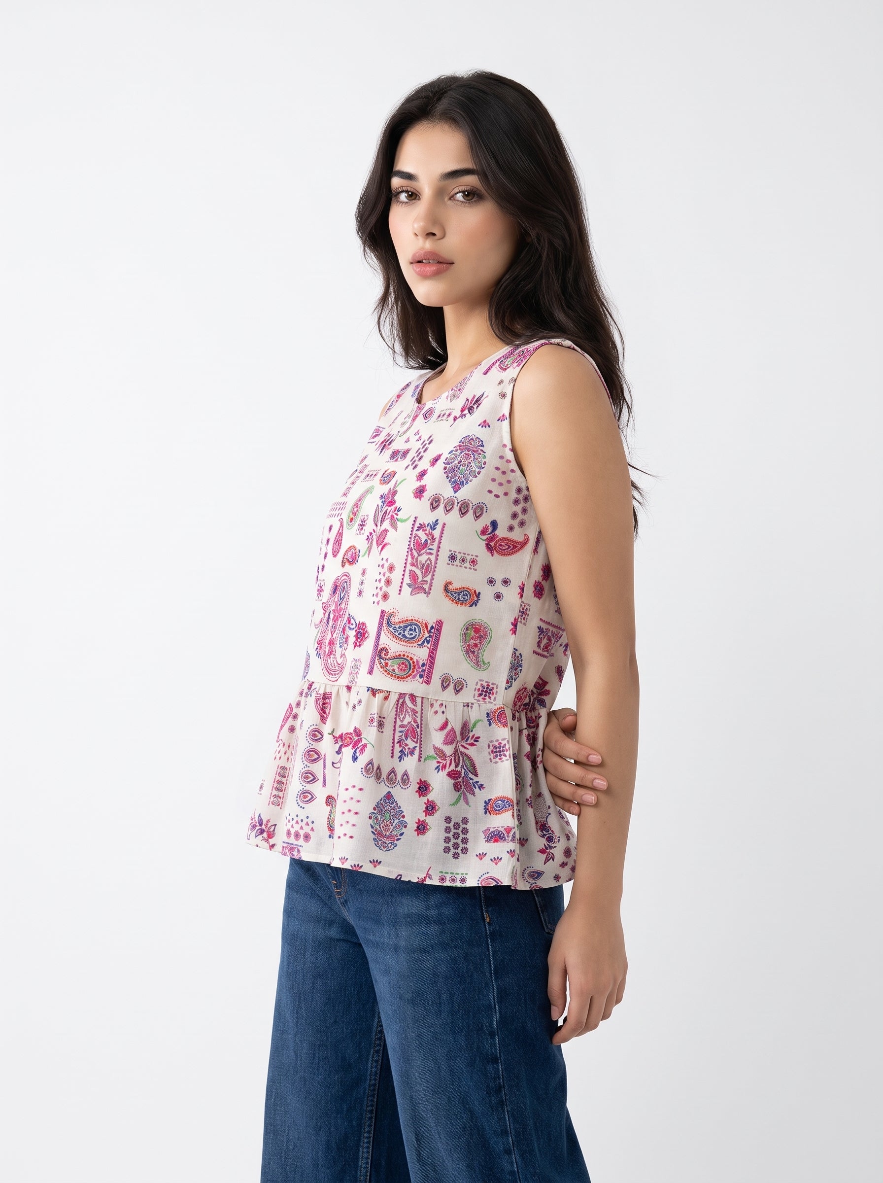 A charming off-white sleeveless top featuring pink, purple, blue, and green paisley motifs for a bright and feminine look.