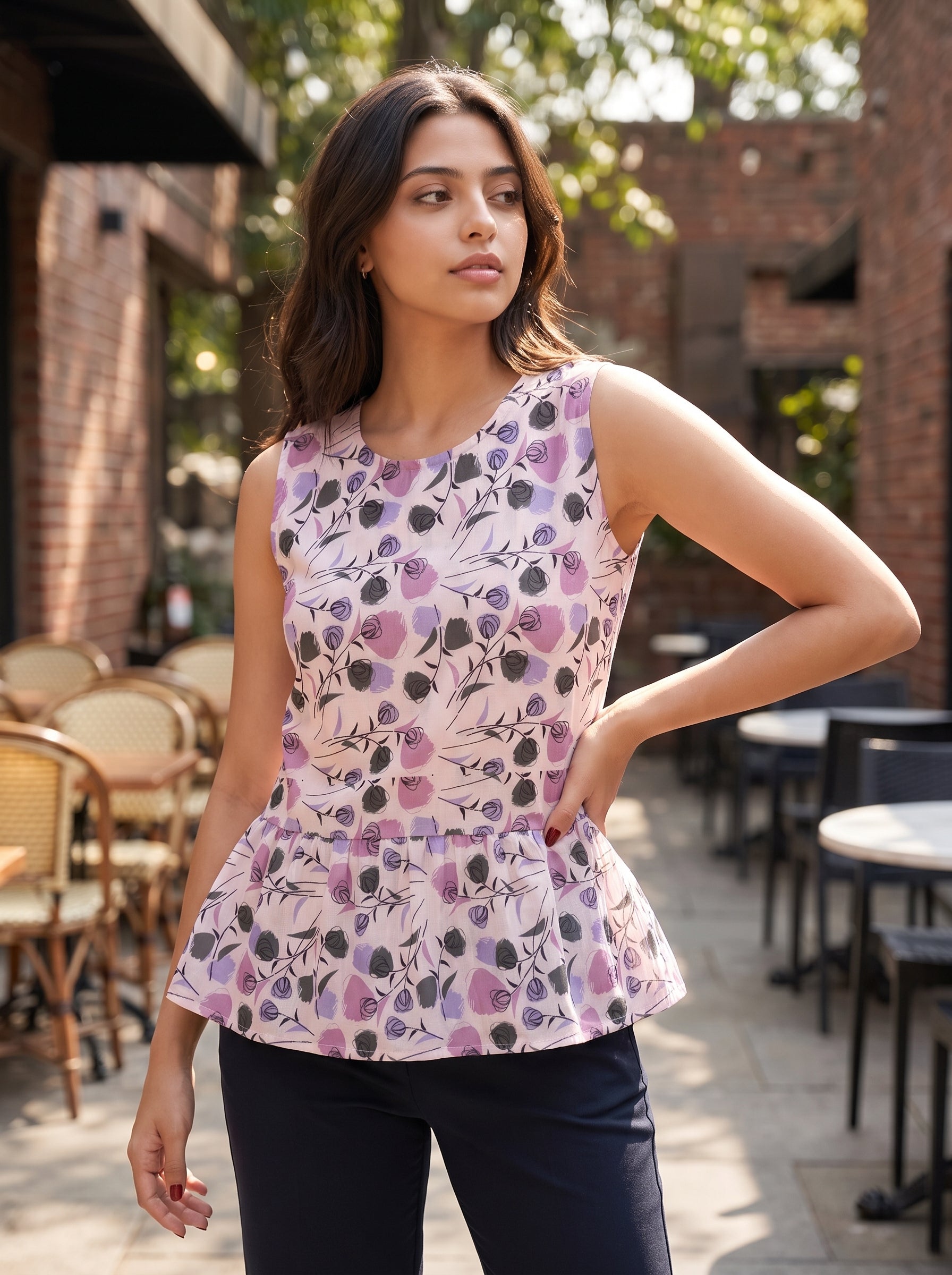 A soft light pink sleeveless top featuring lavender and black rose motifs with artistic botanical accents for a modern feminine look.