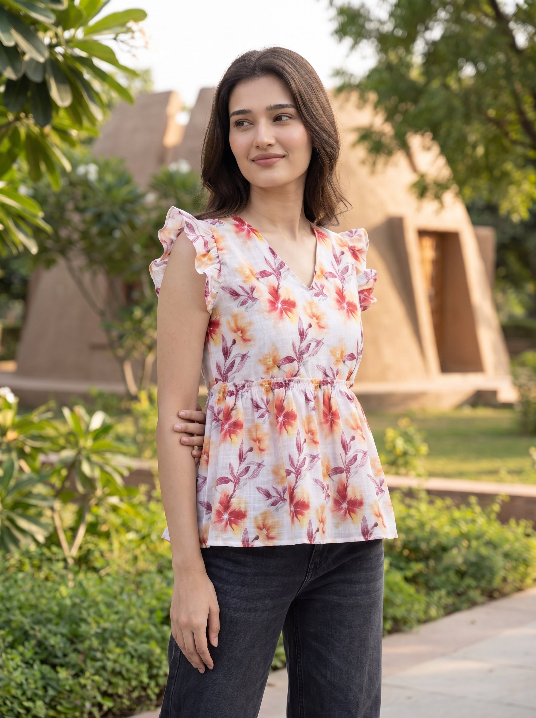 A fresh off-white top featuring rich rust, orange, and burgundy floral motifs for a warm feminine look. 