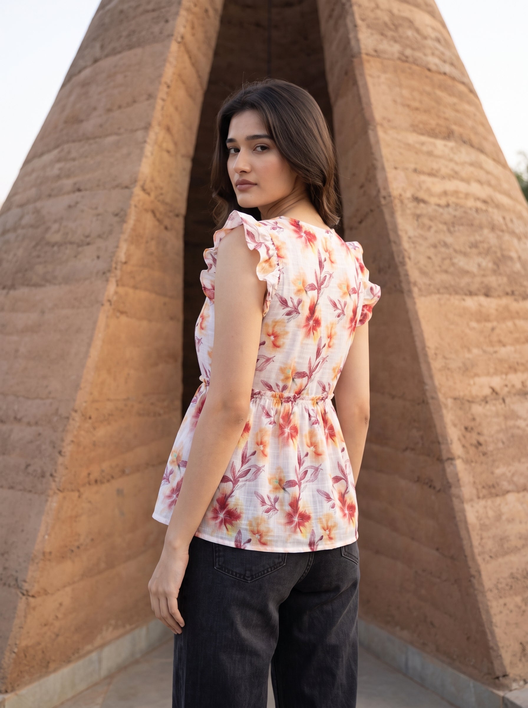 A fresh off-white top featuring rich rust, orange, and burgundy floral motifs for a warm feminine look. 