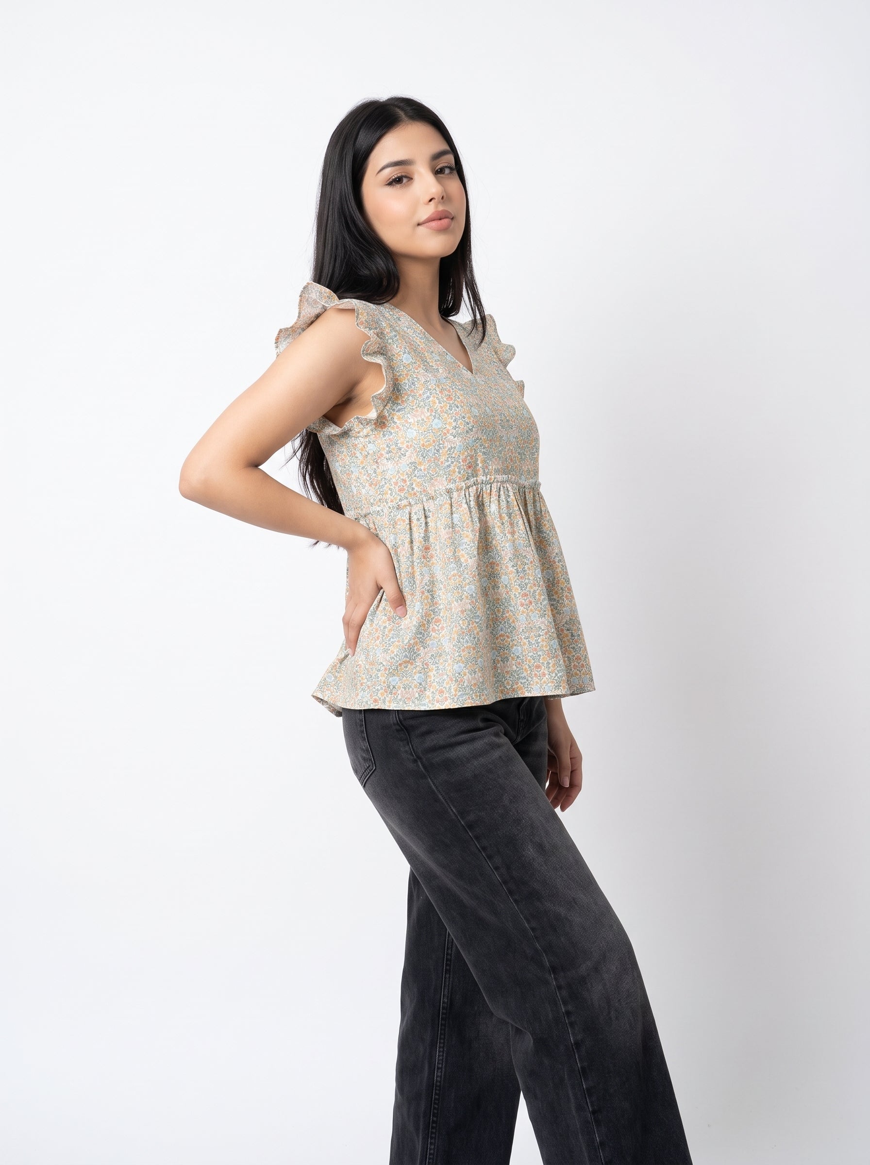 A soft off-white top featuring delicate peach and muted blue floral motifs for a fresh, feminine look.