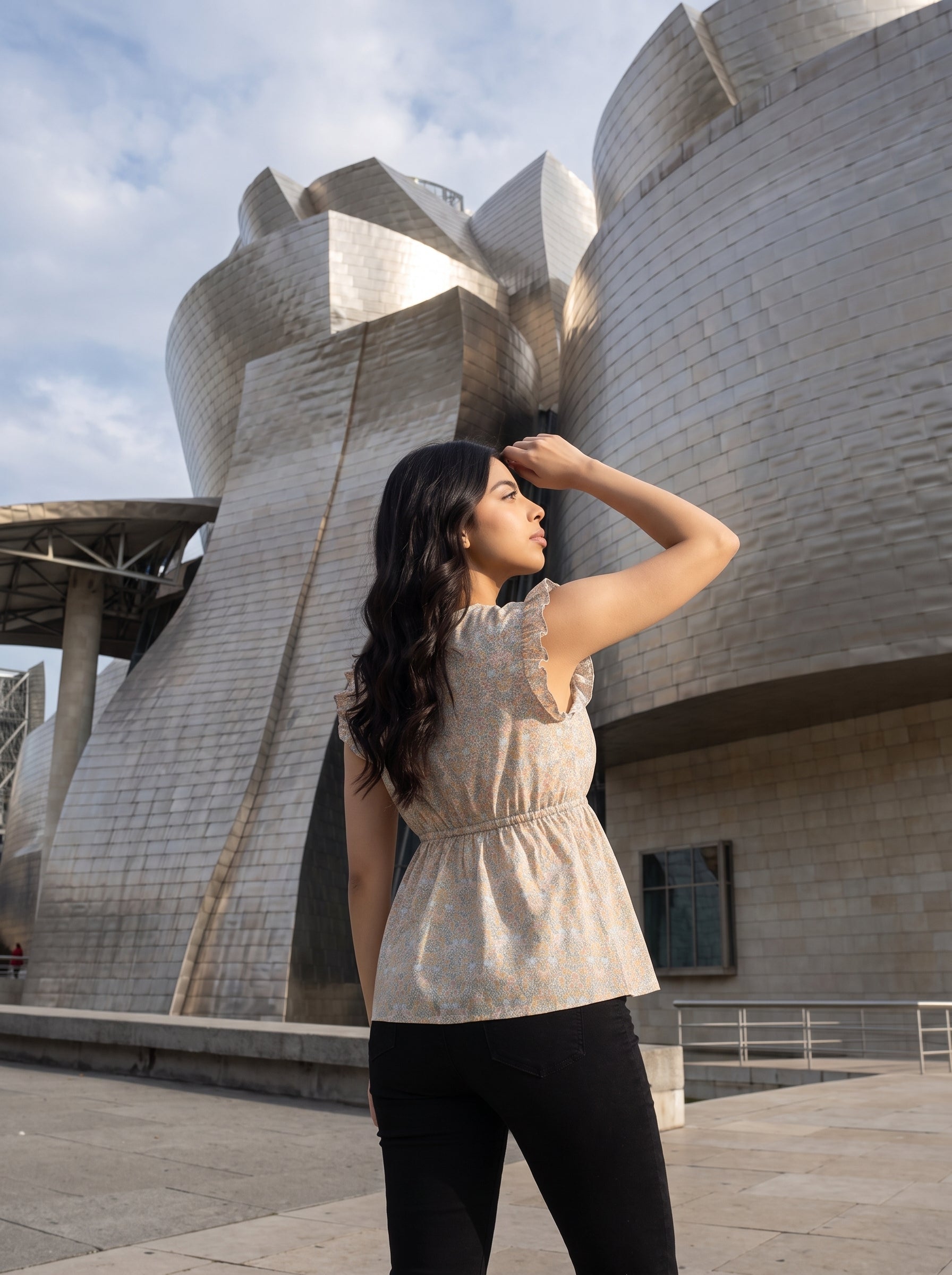 A soft off-white top featuring delicate peach and muted blue floral motifs for a fresh, feminine look.