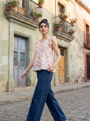 A fresh off-white top featuring soft peach floral motifs with subtle green botanical accents for a feminine everyday look.