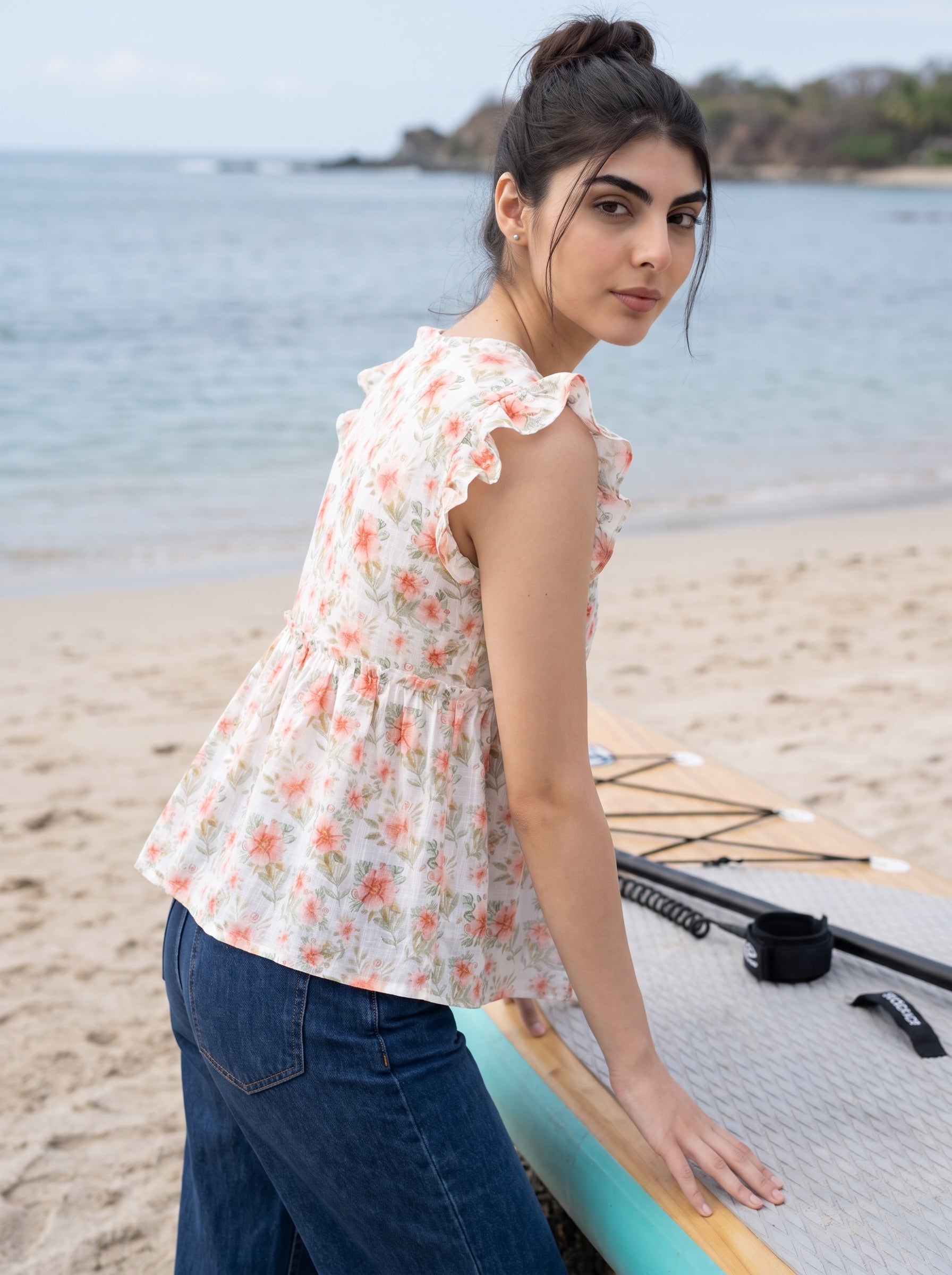 A fresh off-white top featuring soft peach floral motifs with subtle green botanical accents for a feminine everyday look.