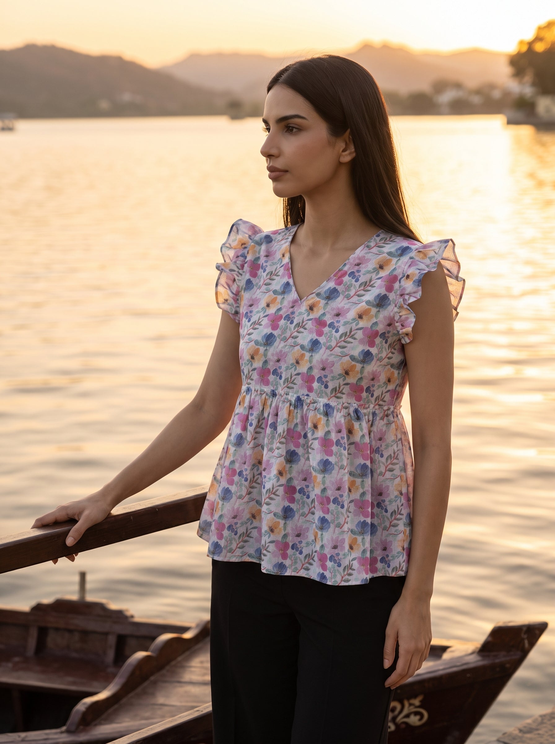 A fresh off-white top featuring soft pink, blue, peach, and green floral motifs for a bright feminine look.
