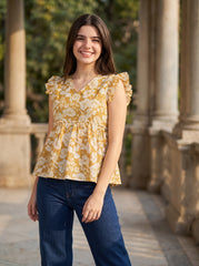 A cheerful mustard yellow top featuring elegant white floral motifs for a bright and feminine look.