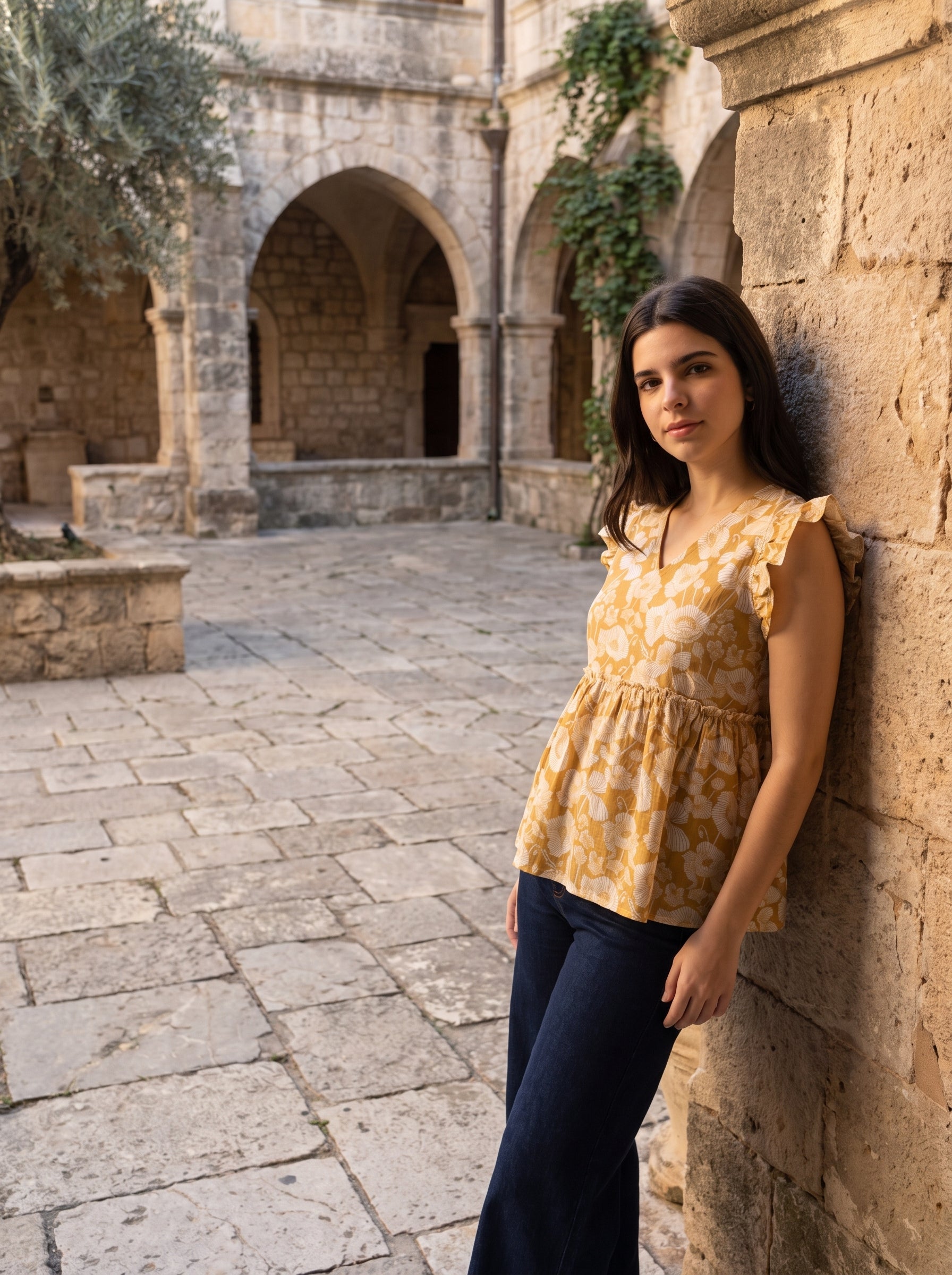 A cheerful mustard yellow top featuring elegant white floral motifs for a bright and feminine look.