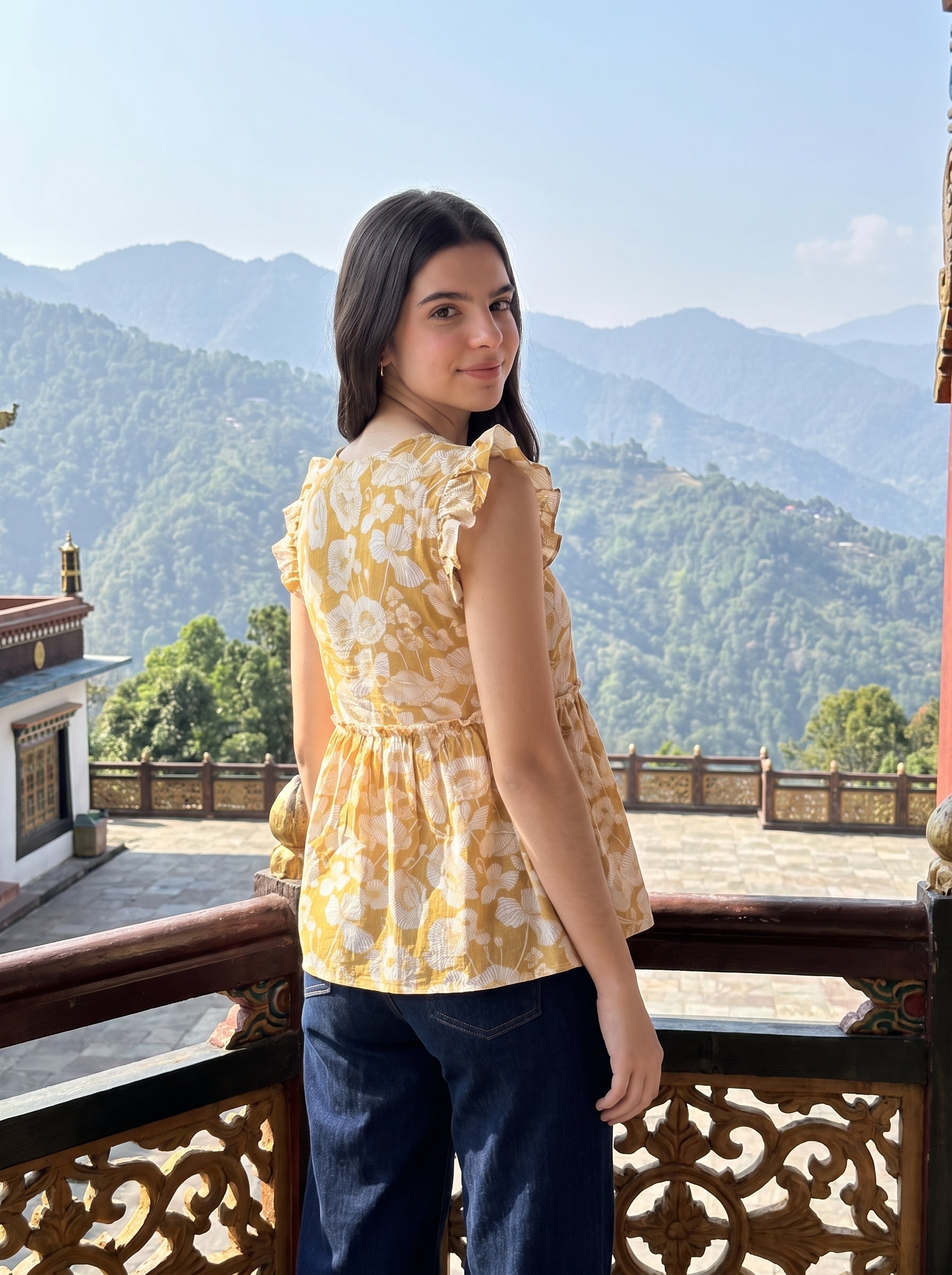 A cheerful mustard yellow top featuring elegant white floral motifs for a bright and feminine look.