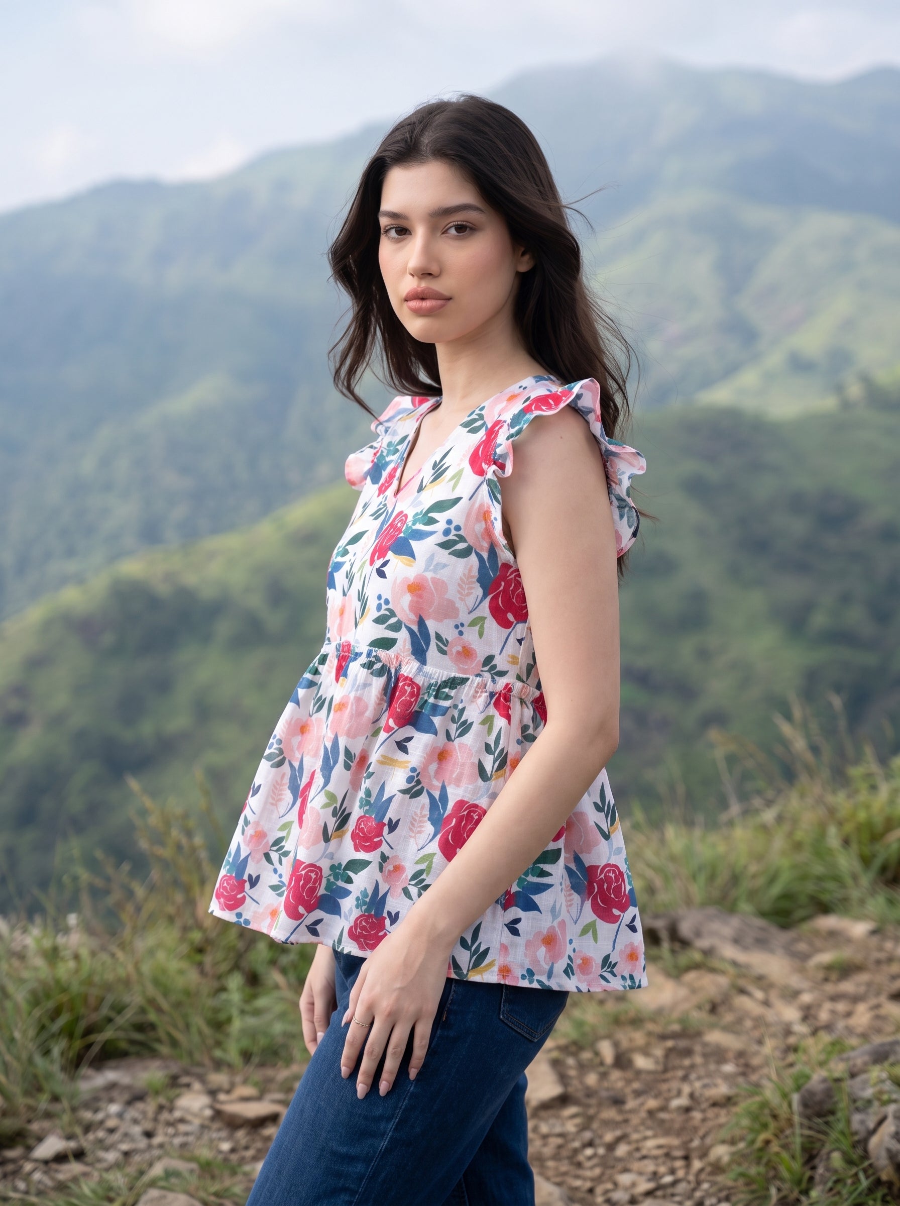 A cheerful floral top featuring bold red and pink roses with blue, green, and mustard botanical accents for a fresh feminine look.