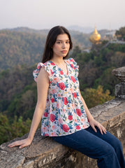 A cheerful floral top featuring bold red and pink roses with blue, green, and mustard botanical accents for a fresh feminine look. 