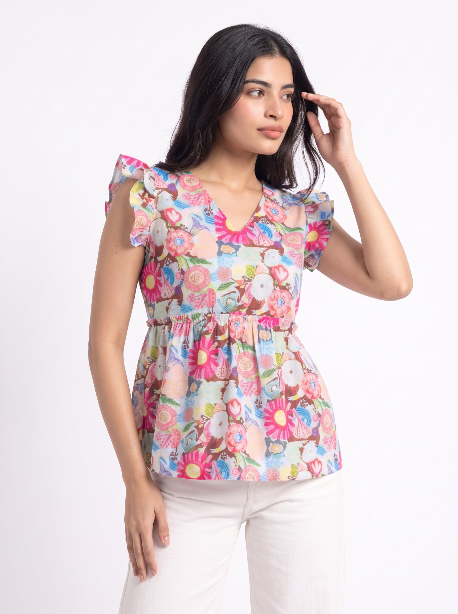 A lively off-white top featuring bright pink, blue, green, peach, and yellow floral motifs for a cheerful statement look. The V-neckline and layered ruffle sleeves add a playful feminine touch, while the gathered peplum waist creates a flattering, flowy silhouette.
