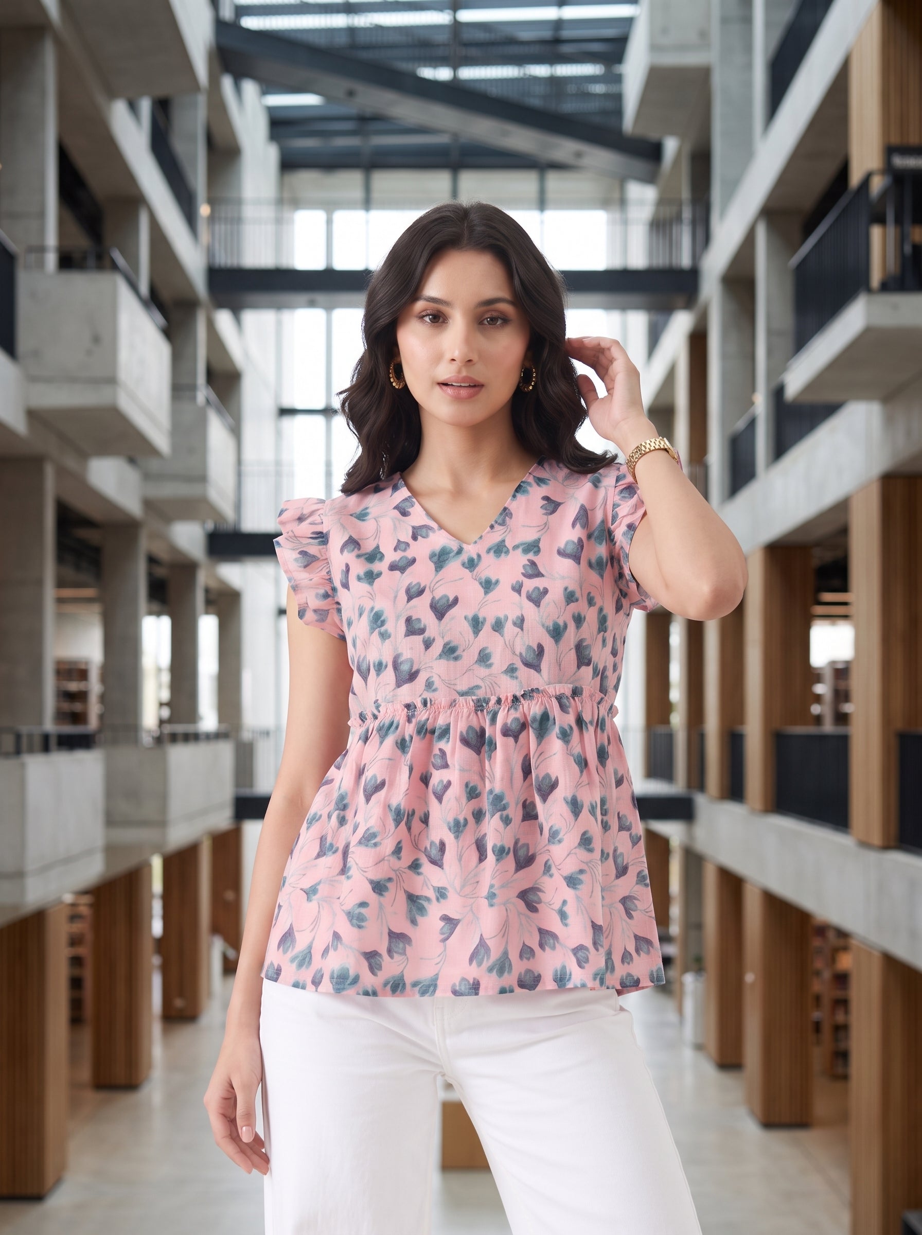 A soft pink top featuring elegant dark teal floral and leafy motifs for a fresh, feminine look. The V-neckline and layered ruffle sleeves add a graceful touch, while the gathered peplum waist creates a flattering, flowy silhouette.