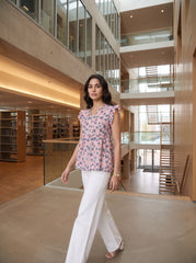 A soft pink top featuring elegant dark teal floral and leafy motifs for a fresh, feminine look. The V-neckline and layered ruffle sleeves add a graceful touch, while the gathered peplum waist creates a flattering, flowy silhouette.