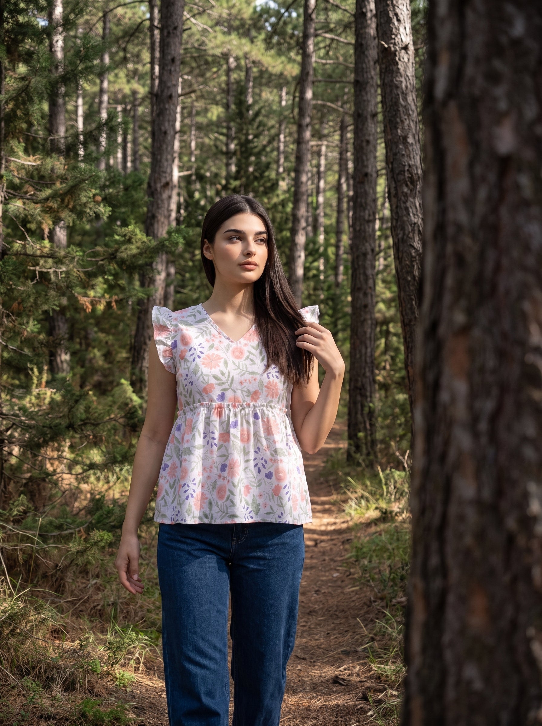A fresh off-white top featuring soft peach florals with green and blue botanical accents for a charming feminine look. 