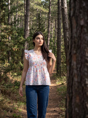 A fresh off-white top featuring soft peach florals with green and blue botanical accents for a charming feminine look. 