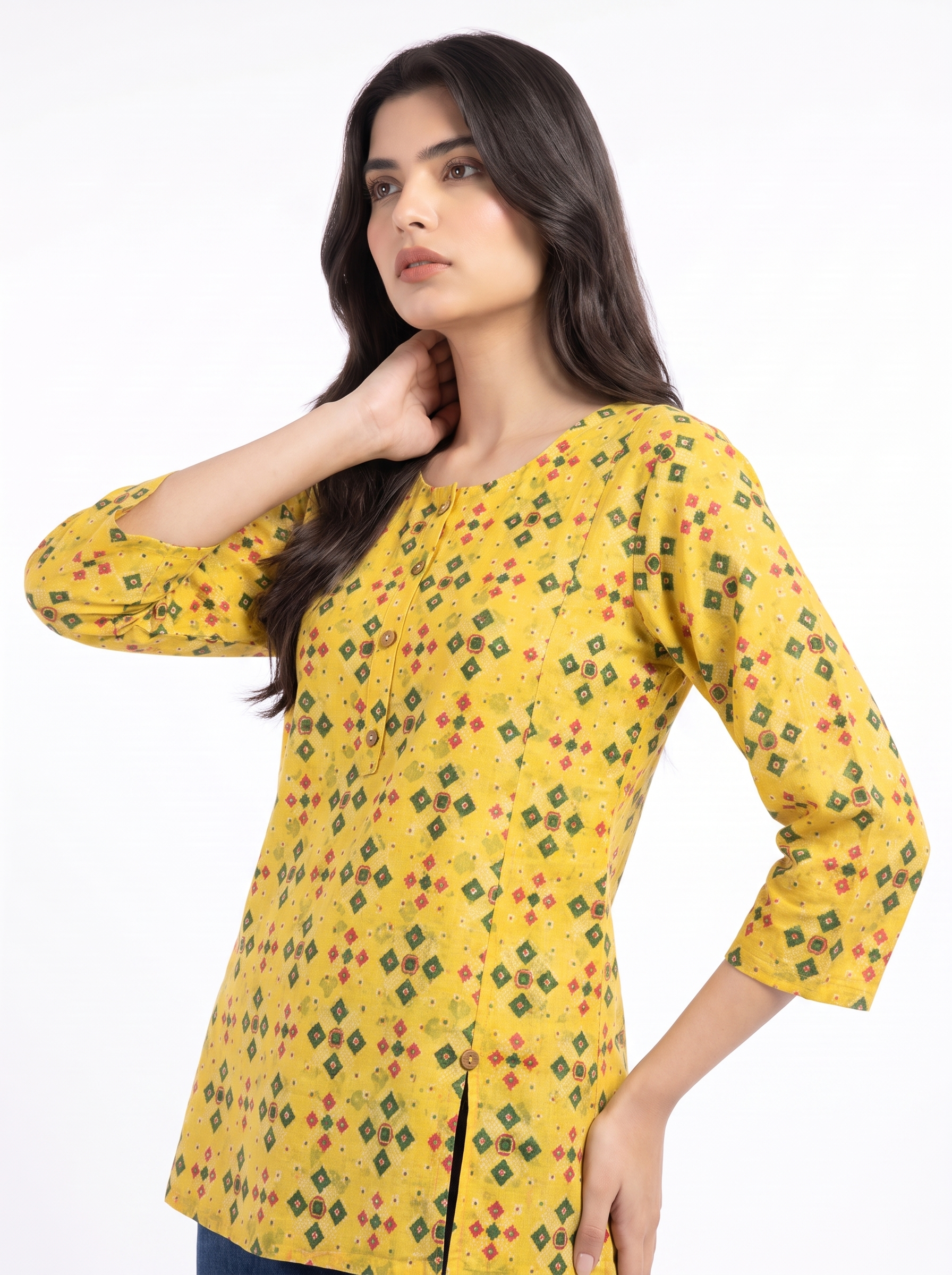 A woman modeling a yellow three-quarter sleeve kurta with a repeating geometric diamond pattern in green, red, and orange, set against a plain white studio background.